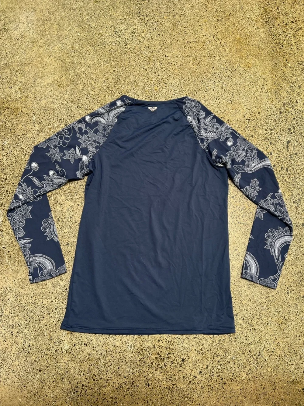 Roxy rashguard in blue with white floral design at sleeves